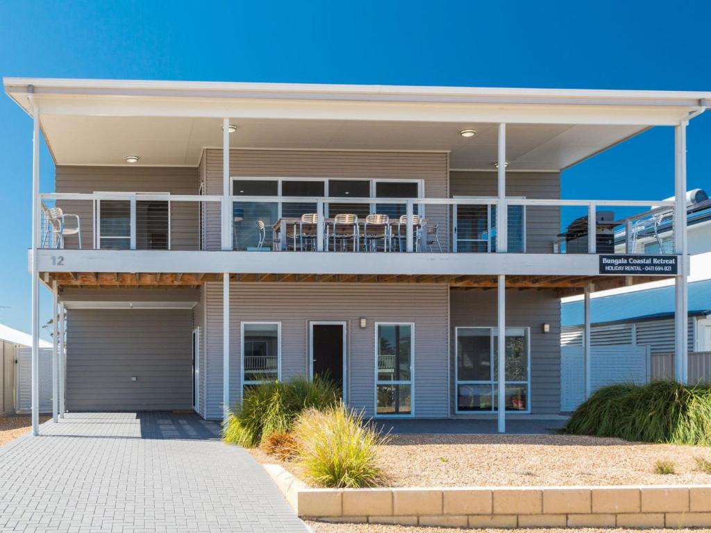 a house with a balcony with chairs on it at Bungala Coastal Retreat 12 Nereus Drive in Normanville