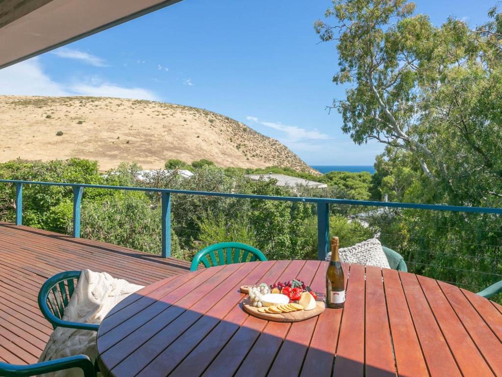 a table with a bottle of wine and a basket of fruit at Seven on Scenic - 7 Scenic View Drive, Second Valley in Second Valley