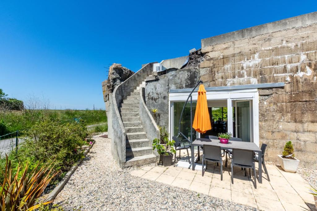 a patio with a table and an umbrella at Blockhaus 44 in Ver-sur-Mer