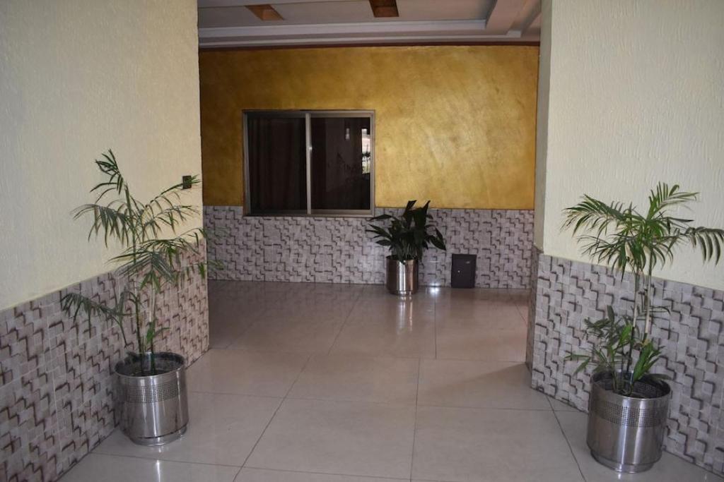 um corredor com três vasos de plantas num edifício em Manama Hotel em Islamabad