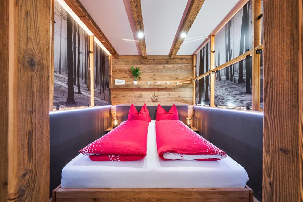 a bed in a train car with red pillows at Landhotelwohnung in Seeg in Seeg