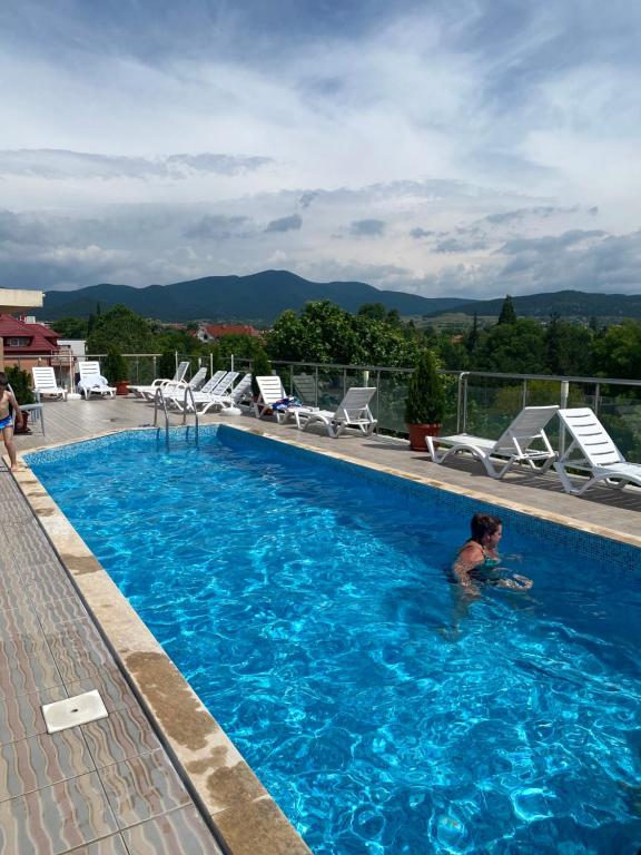 a man swimming in a large swimming pool at Fantasy Apartment 15 комплекс Фантазия, Хисаря in Hisarya