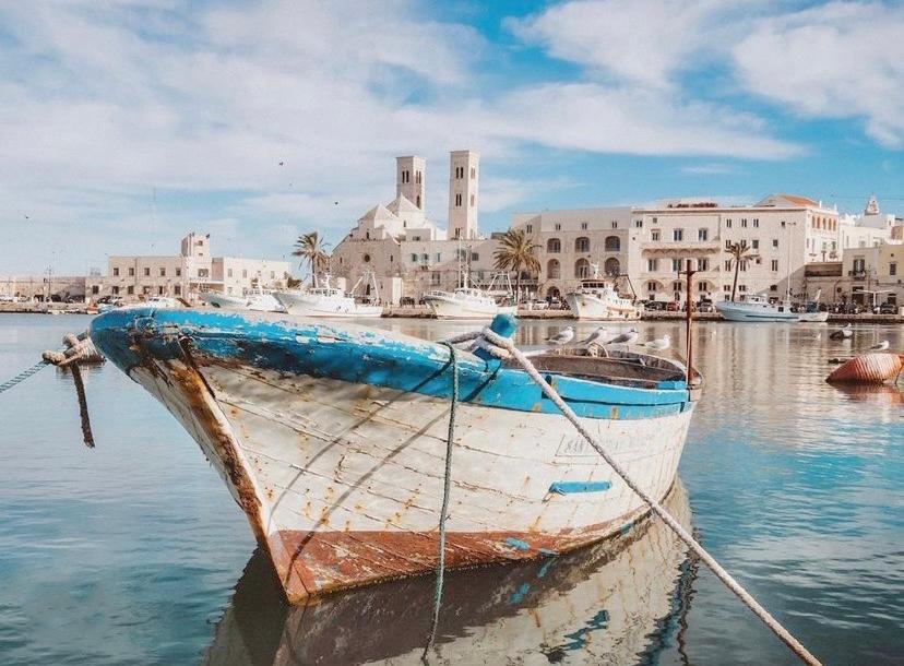 łódź siedząca w wodzie przed miastem w obiekcie INDE Á LA TERRE, GUEST HOUSE Locazione Turistica w mieście Molfetta