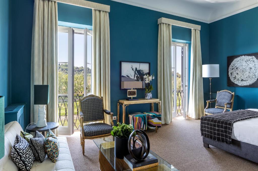a hotel room with blue walls and a bed and chairs at 4F Boutique Hotel Florence in Florence