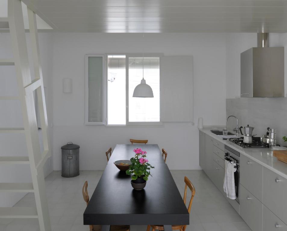 a kitchen with a table with a vase of flowers on it at Centric Townhouse CADAQUÉS - Casa Voltes - in Cadaqués