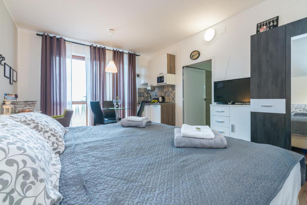 um quarto com uma cama grande e uma televisão em Apartman Chiara em Rijeka