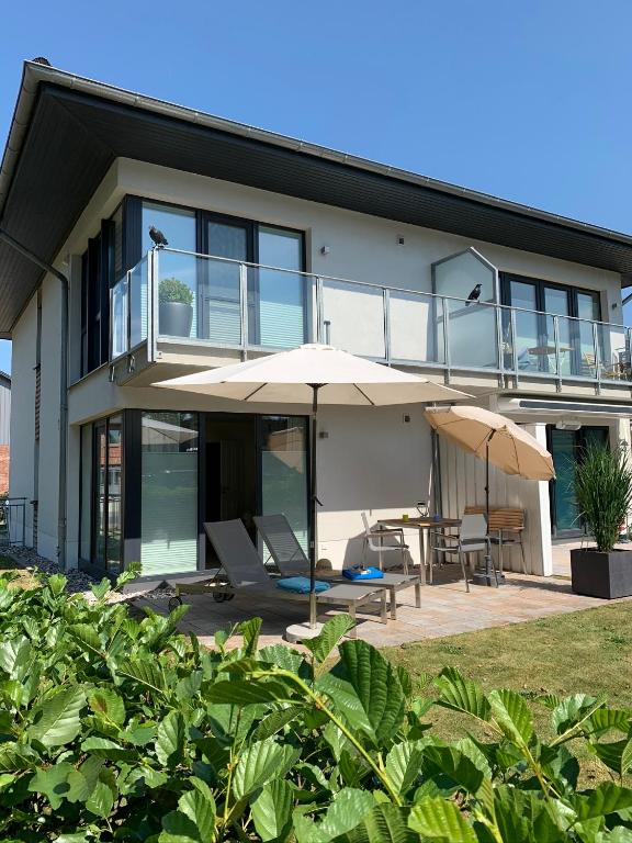 a house with an umbrella and a table and chairs at Beach Home in Böhl