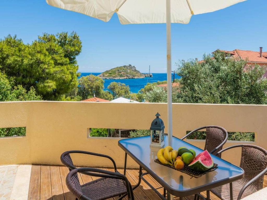 una mesa con un bol de fruta y una sombrilla en Armiriki Holiday Home, en Agios Nikolaos