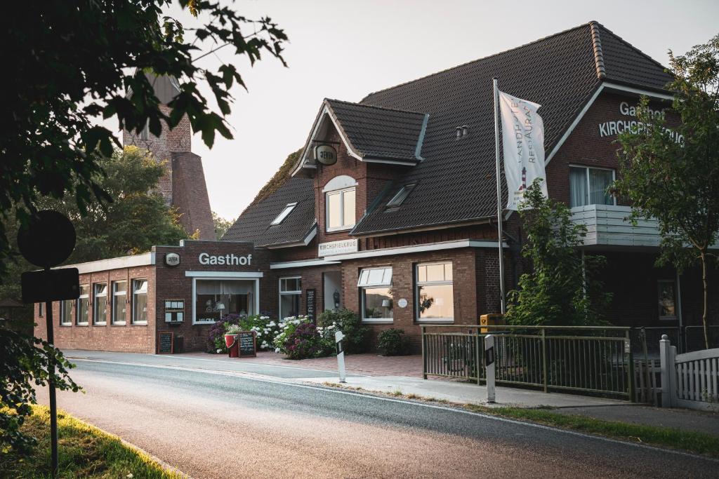 a building with a sign on the side of a street at Kirchspielkrug Landhotel & Restaurant in Westerhever