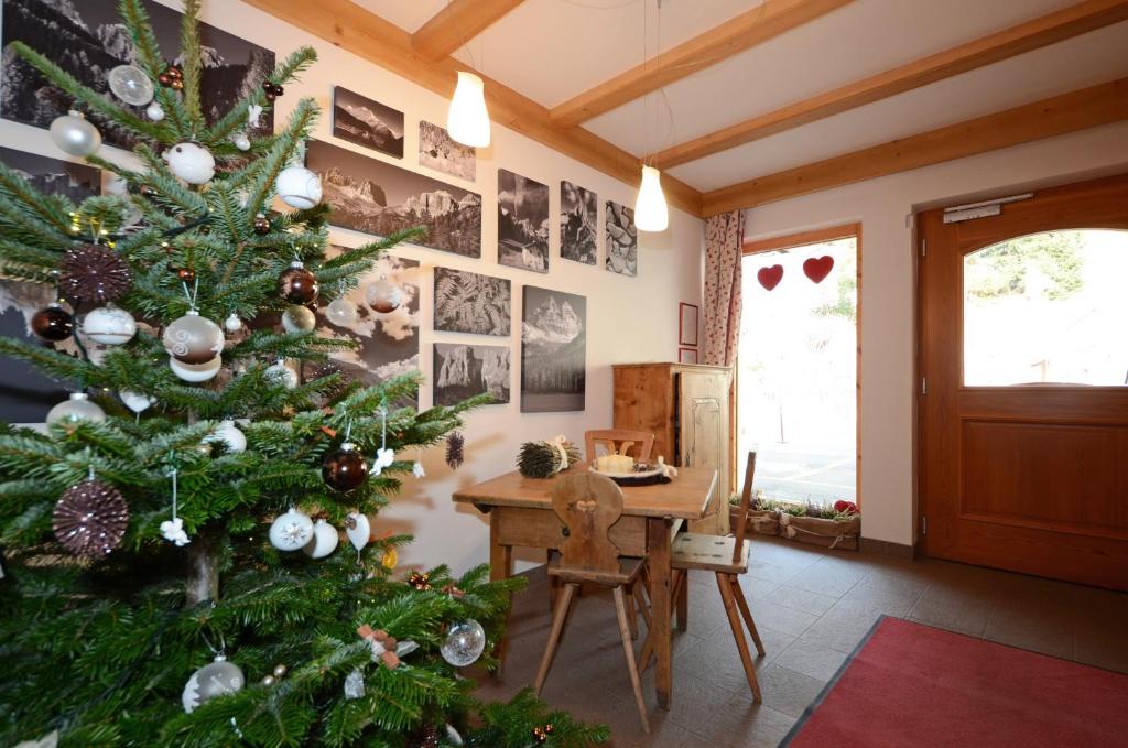 a christmas tree in a room with a table at Appartamenti Maria in Canazei