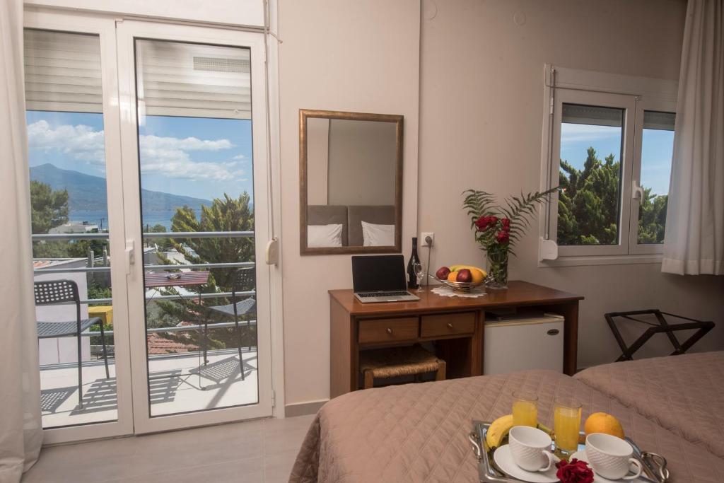 a bedroom with a bed and a desk with a mirror at Filoxenia Hotel in Volos