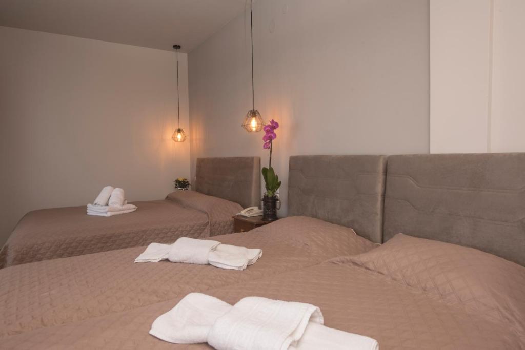 a room with two beds with towels on them at Filoxenia Hotel in Volos
