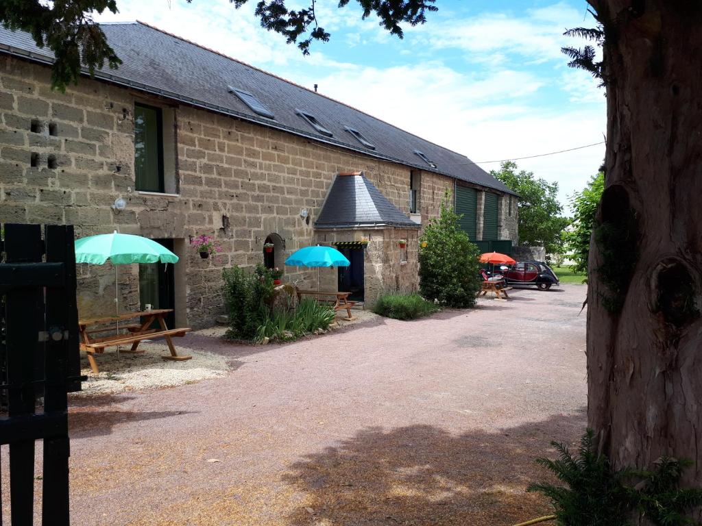 a building with benches and umbrellas in front of it at Celtic Rivers in Doué-la-Fontaine