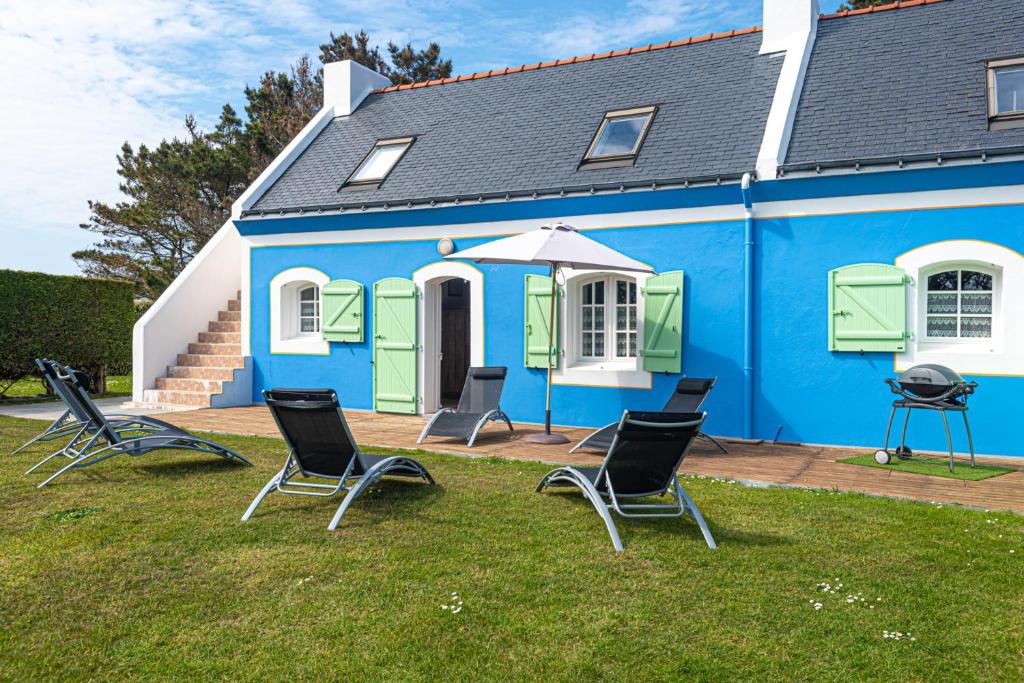 une maison bleue avec des chaises devant elle dans l'établissement Maison de charme à Bangor avec grand jardin clos, à Bangor