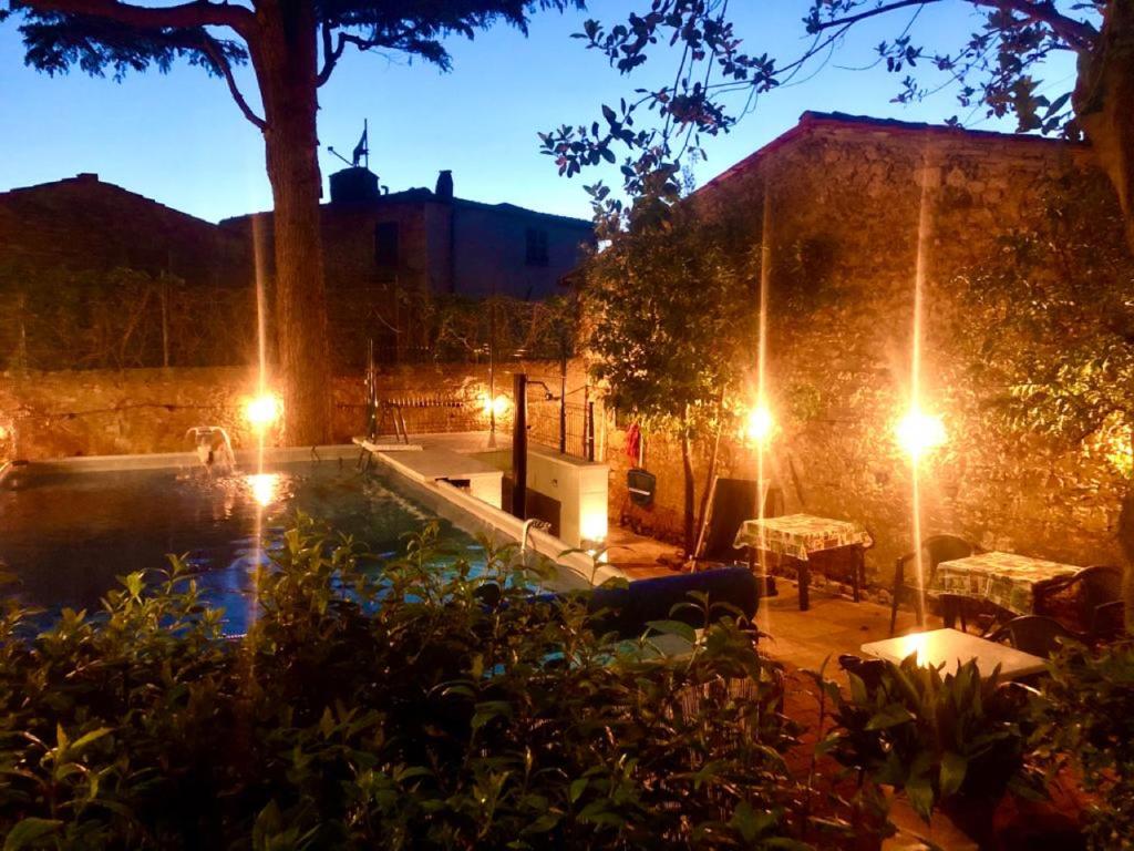 a backyard with a pool at night with lights at Locanda Etrusca in Bibbona