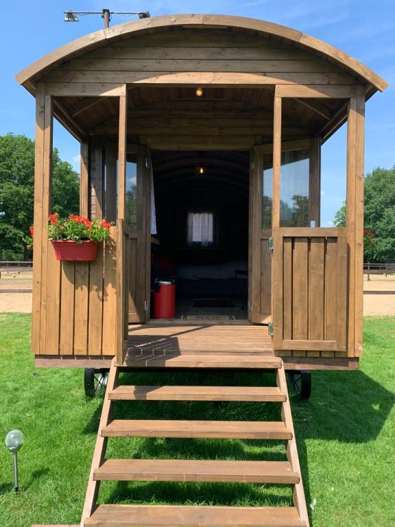 - un kiosque en bois avec une terrasse couverte sur la pelouse dans l'établissement Pipowagen Het Kasteel, à Diever