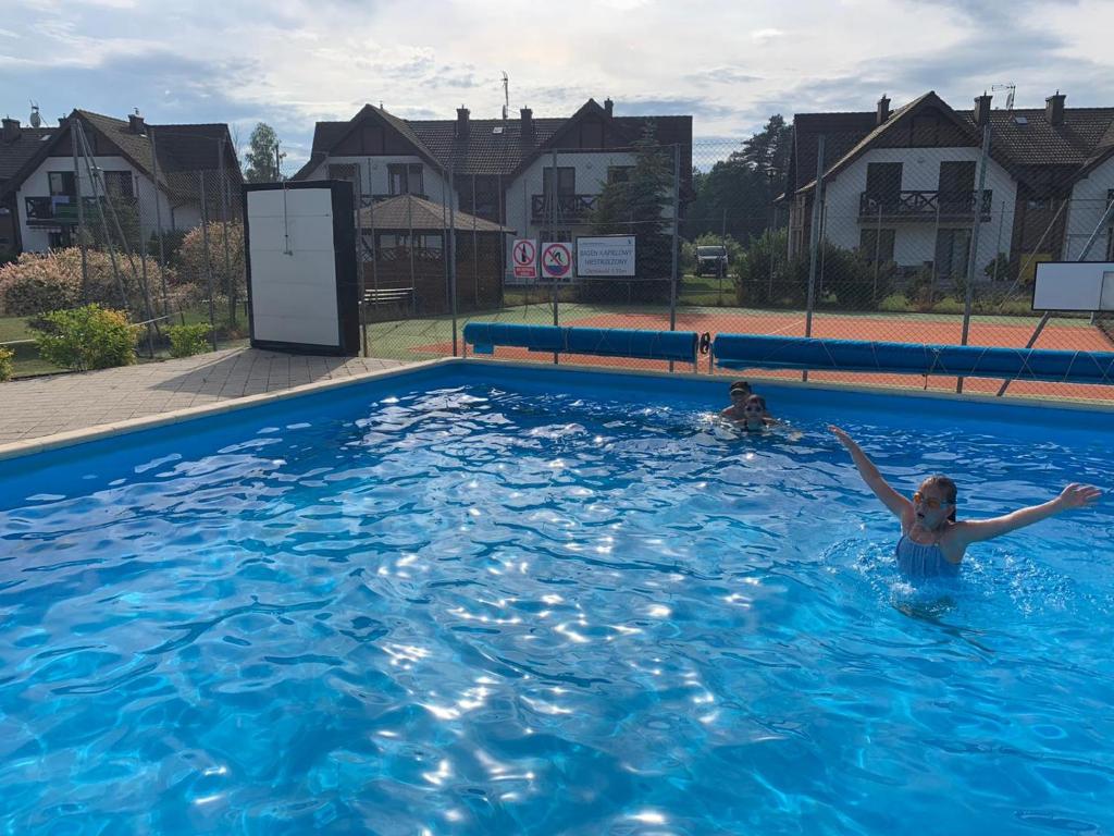 a woman is swimming in a swimming pool at Nadmorski in Żarnowska
