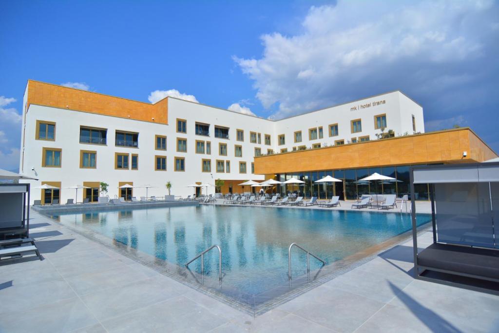 a large swimming pool in front of a building at mk hotel tirana in Tirana