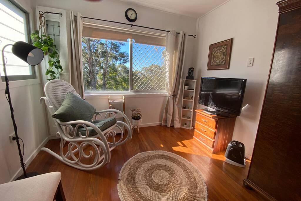 a living room with a chair and a television at Cozy self-contained unit surrounded by nature in Goonellabah