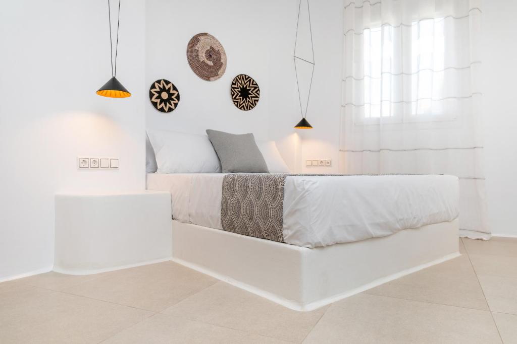 een witte slaapkamer met een bed en een witte muur bij Naxos DownTown Apartments & Suites in Naxos Chora