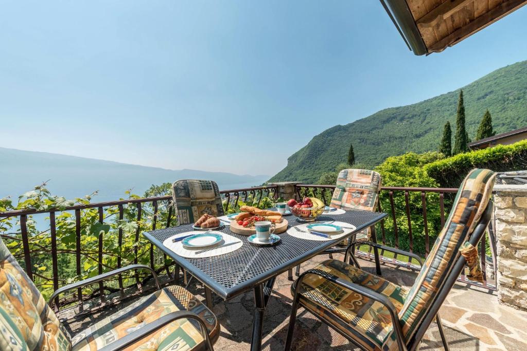 una mesa y sillas en un balcón con vistas en Apartment in Villa vista sole, en Tignale