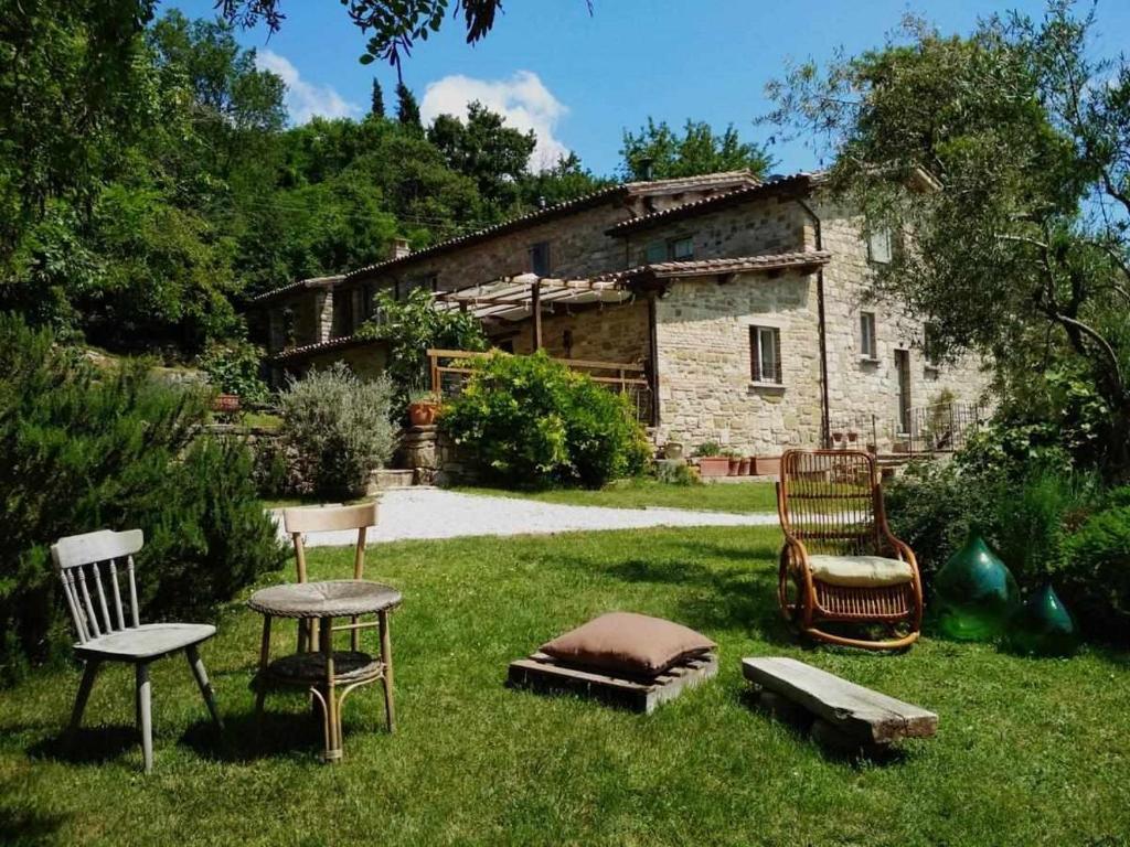 a group of chairs sitting in the grass in front of a building at Agriturismo Montesalce in Gubbio
