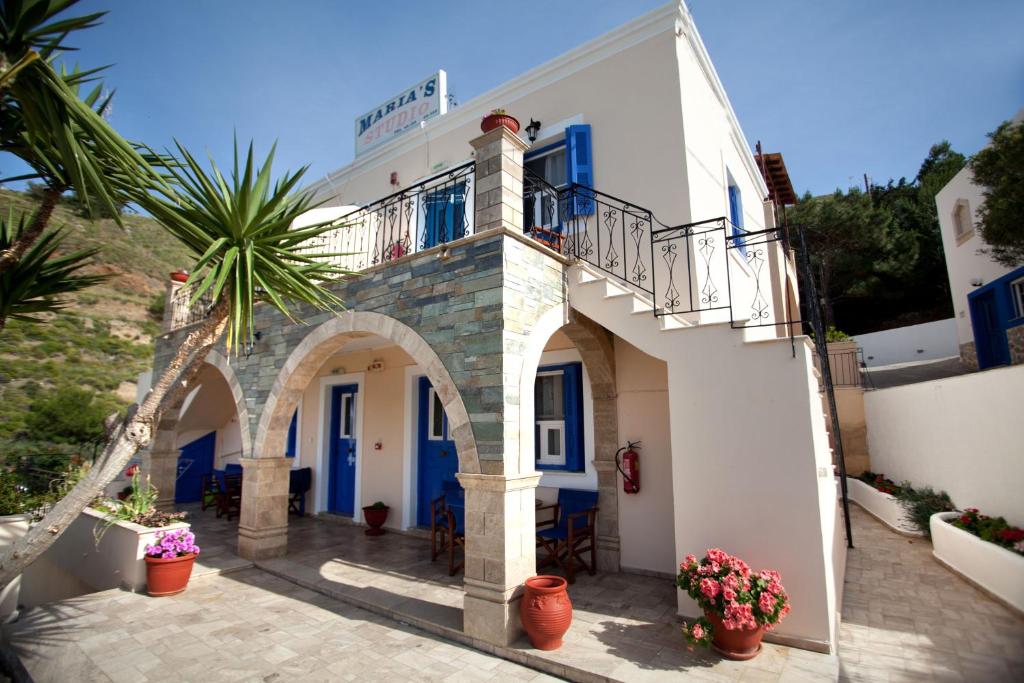 a white building with a balcony and a courtyard at Maria's Studios in Myrties