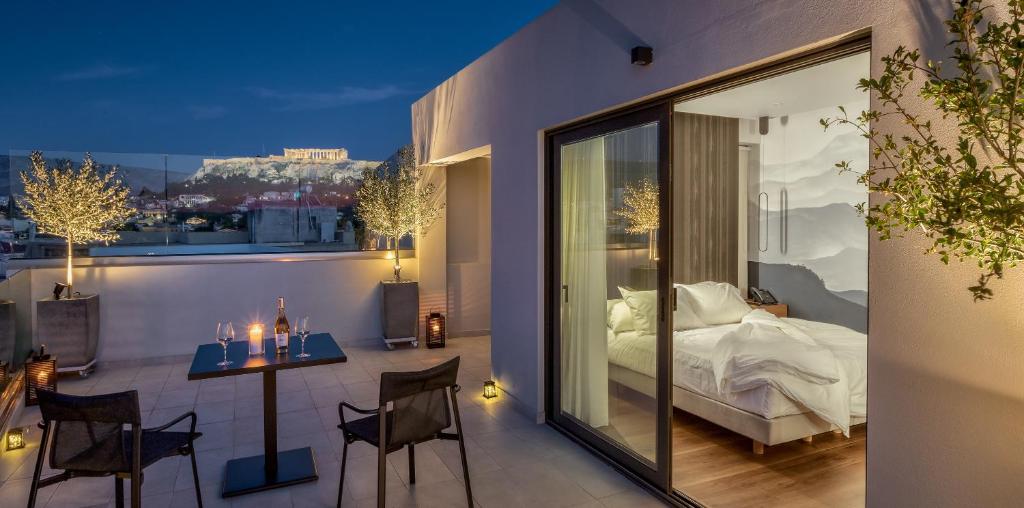 a room with a bed, a table and a window at Ivis 4 Boutique Hotel in Athens