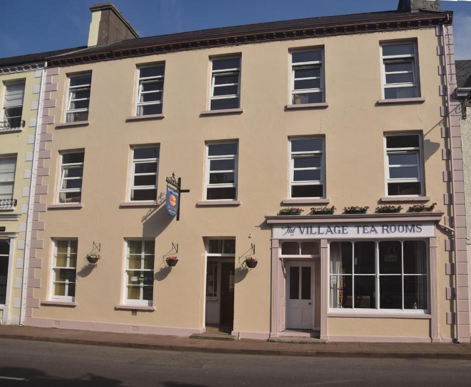 un edificio con un cartel para los salones de té de walesker en The Village Bed and Breakfast en Cushendall