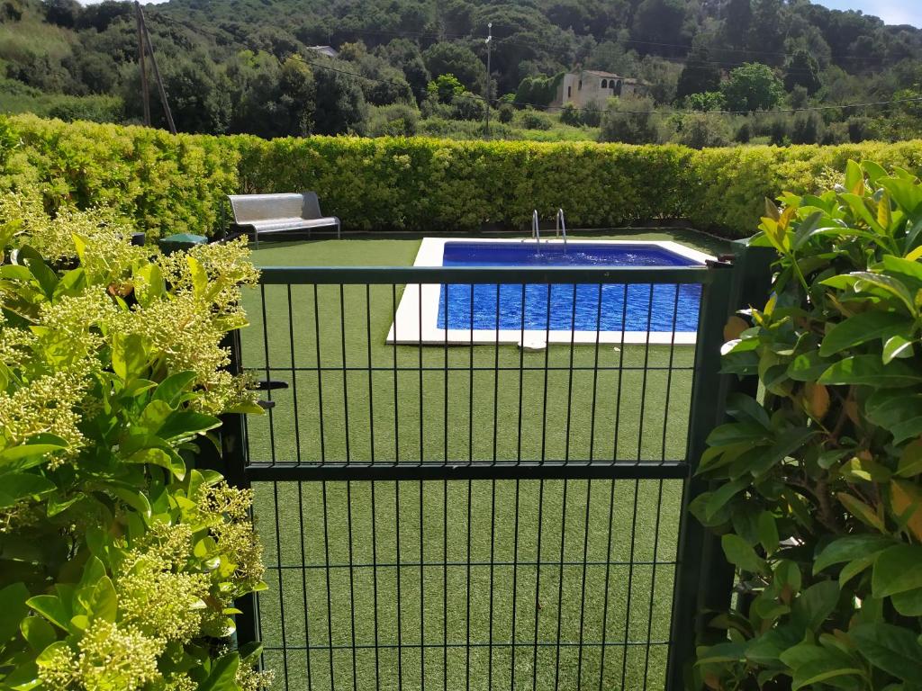 una valla negra con una piscina en un jardín en Apartamento Arenys de Munt - Costa Barcelona, Maresme -, en Arenys de Munt