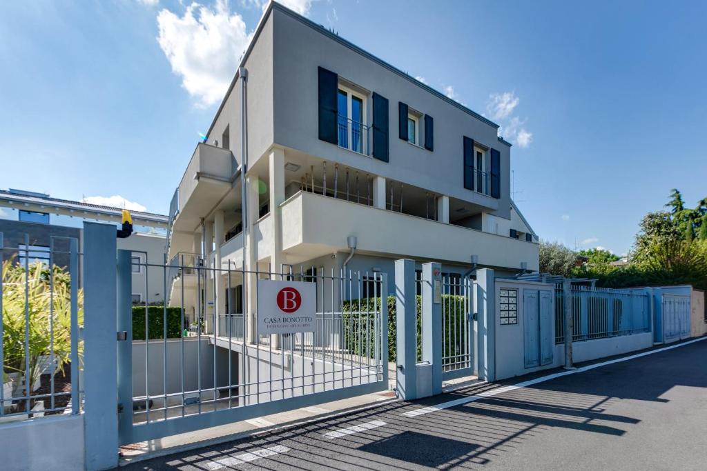 a white building with a gate and a fence at Casa Bonotto in Desenzano del Garda