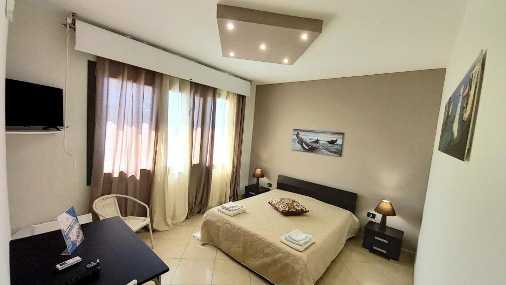 1 dormitorio con cama, mesa y ventana en B&B Colori del Salento, en Presicce