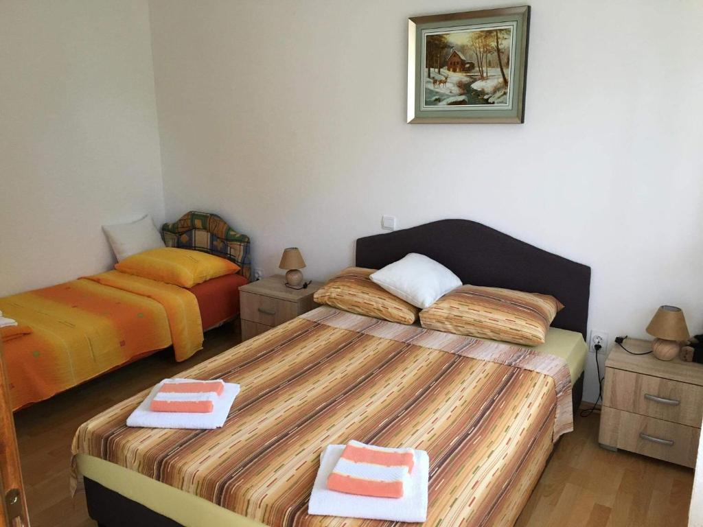 - une chambre avec 2 lits et des serviettes dans l'établissement Apartman Čičković, à Bijela