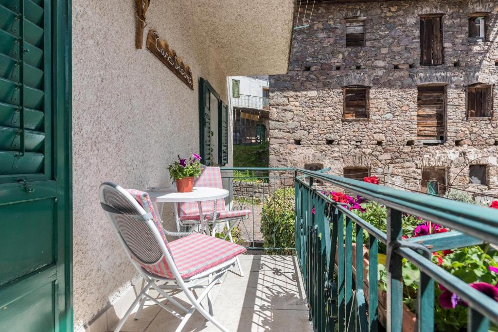 a balcony with chairs and a table and a building at Casa Sicina Alberto in Valfloriana