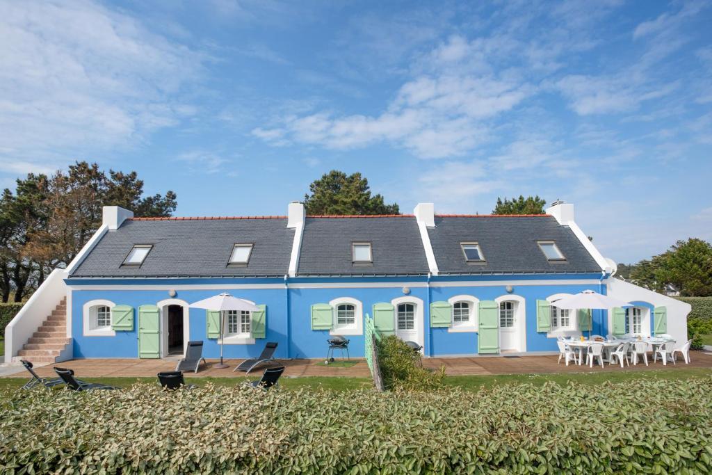 uma casa azul e branca com mesas e cadeiras em Maison de 6 chambres a Bangor a 500 m de la plage avec jardin clos et wifi em Bangor