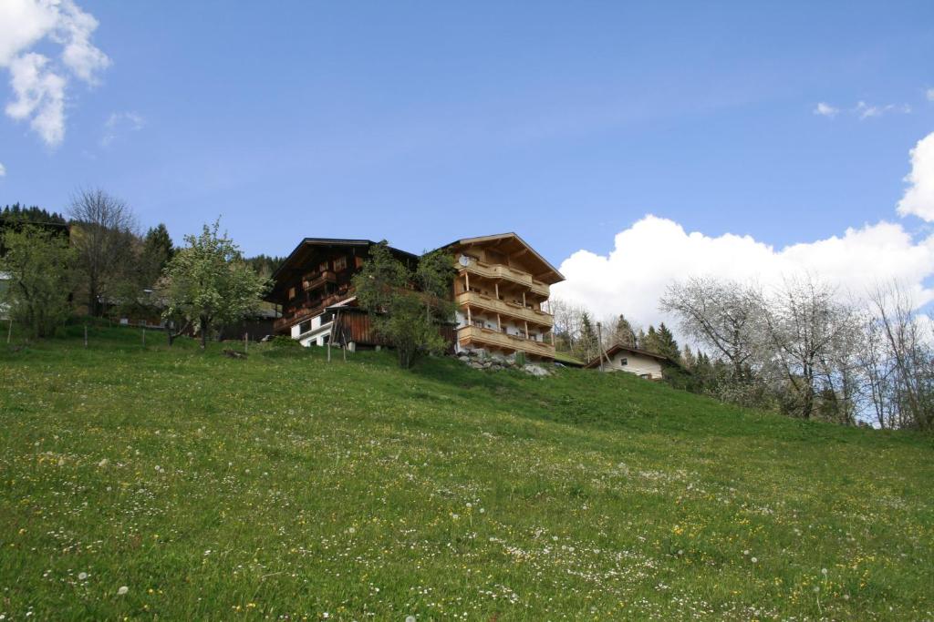 ein Gebäude auf einem Hügel mit einem Feld in der Unterkunft Haus Burbach in Zellberg