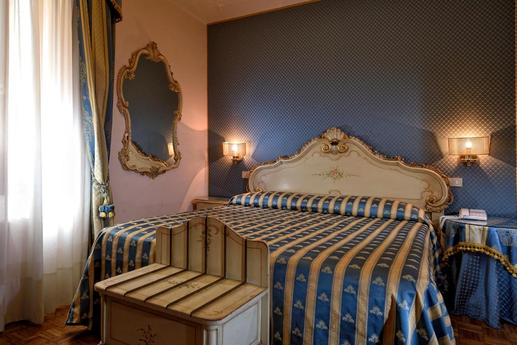 a bedroom with a bed with a striped comforter at Royal San Marco Hotel in Venice