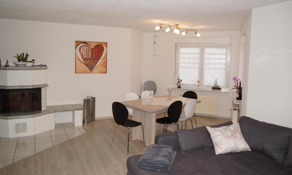 ein Wohnzimmer und eine Küche mit einem Tisch und einem Sofa in der Unterkunft Ferienwohnung Leon in Kappel-Grafenhausen