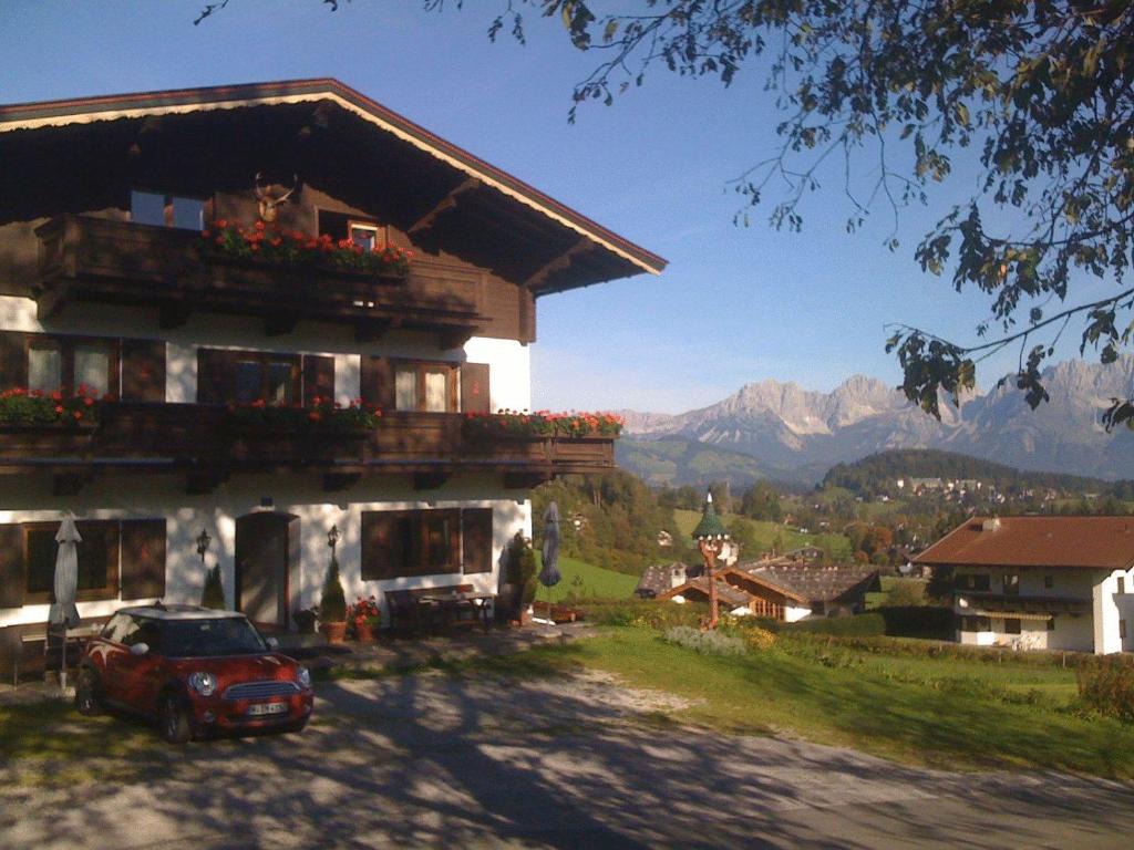 a house with a red car parked in front of it at Pension Feiersinger in Kitzbühel