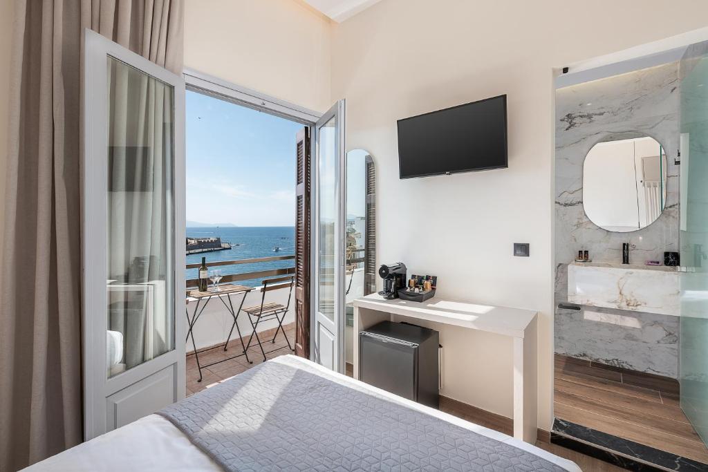 a hotel room with a bed and a view of the ocean at Amphitrite Hotel in Chania