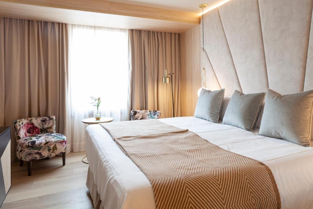 A bed or beds in a room at Nivia Born Boutique Hotel