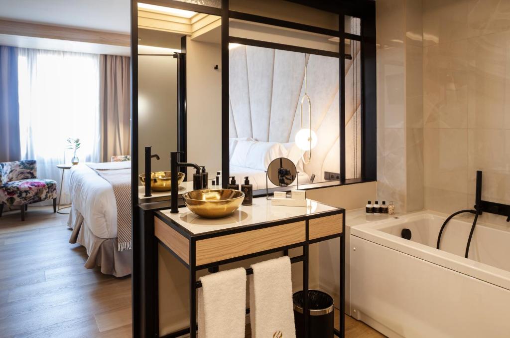 ein Bad mit einem Waschbecken, einer Badewanne und einem Bett in der Unterkunft Nivia Born Boutique Hotel in Palma de Mallorca