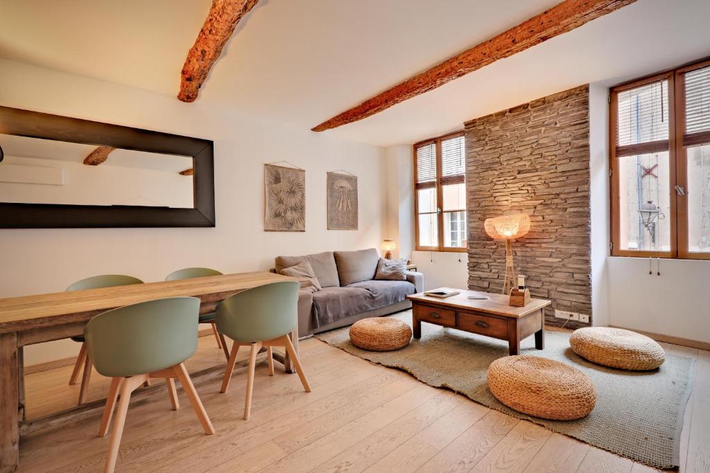 een woonkamer met een tafel en stoelen en een bank bij Le ST Tropez in Saint-Tropez