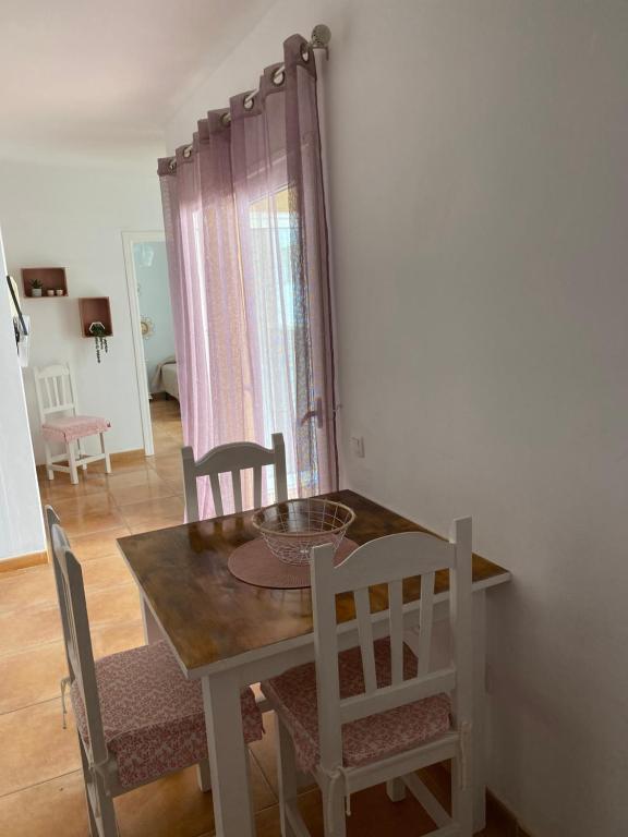 jadalnia z drewnianym stołem i krzesłami w obiekcie Center Holiday Corralejo 2 w Corralejo