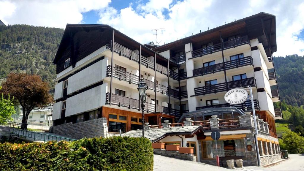 duży budynek z zegarem na boku w obiekcie HG Hotel Italia w mieście Brusson