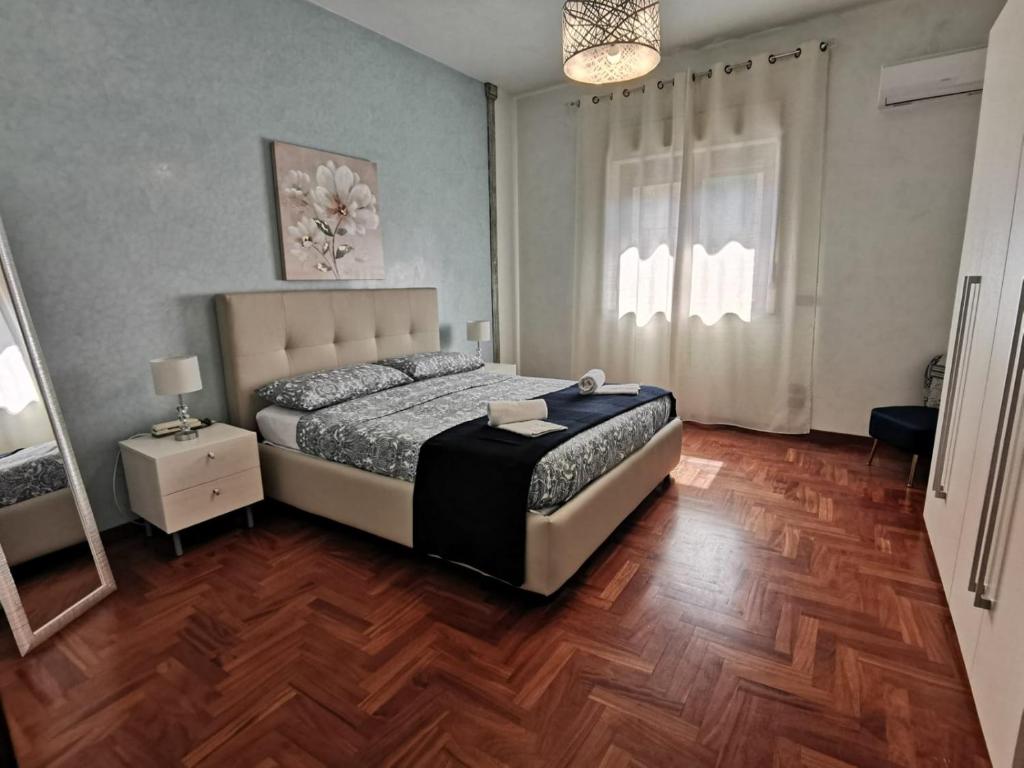 a bedroom with a bed and a wooden floor at Casa Ruby in Misterbianco