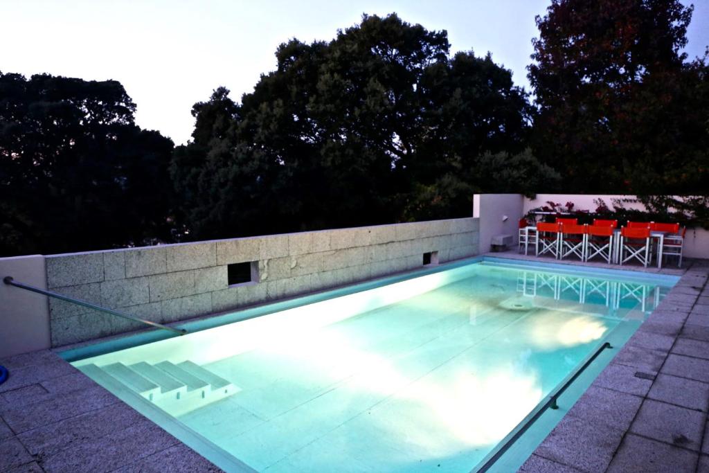 a swimming pool with a table and chairs in it at Liiiving in Moledo - Countryside Pool Villa in Cristelo