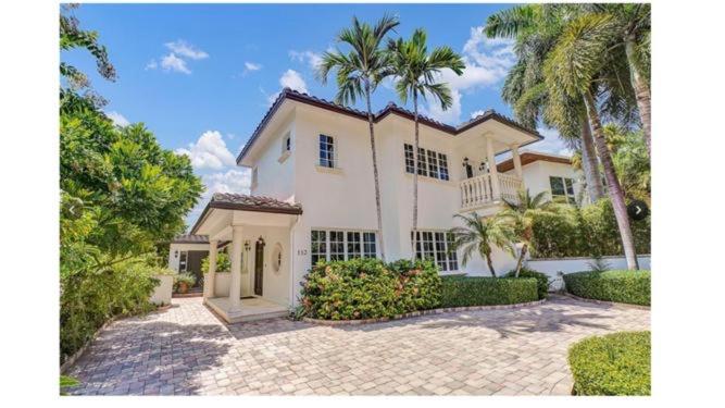 a large white house with palm trees and a driveway at Mediterranean Paradise in Fort Lauderdale