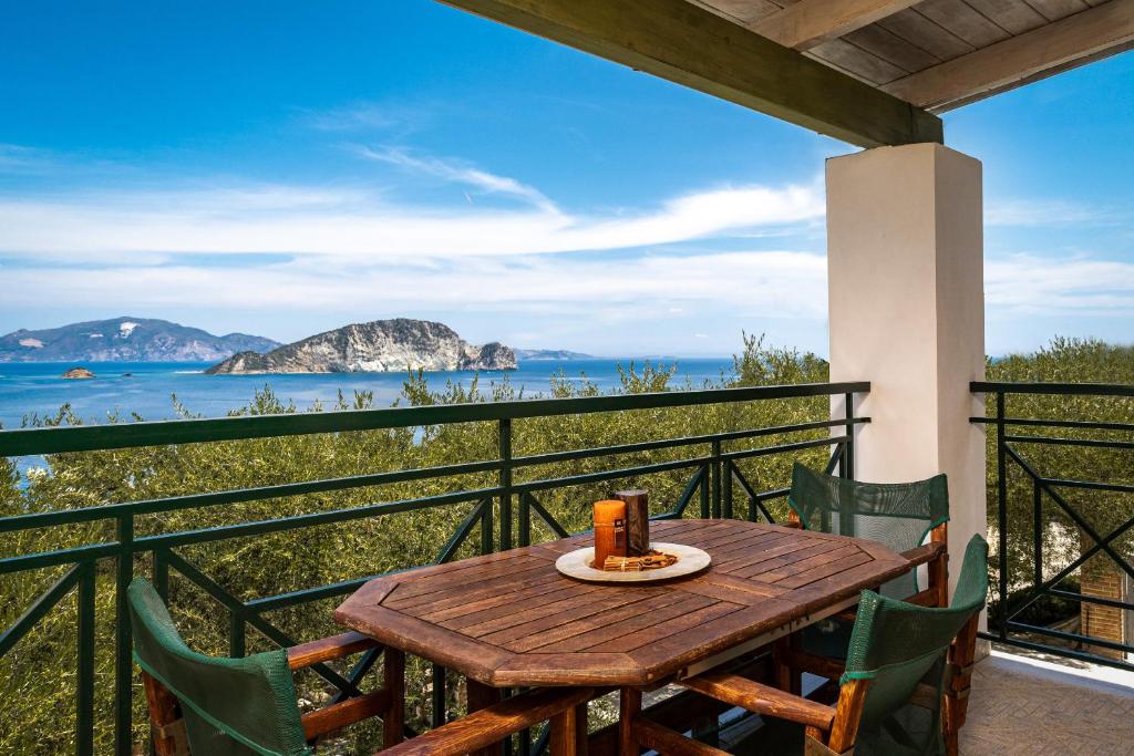 a wooden table on a balcony with a cake on it at Keri Marathias Pavezzo Villa in Marathias