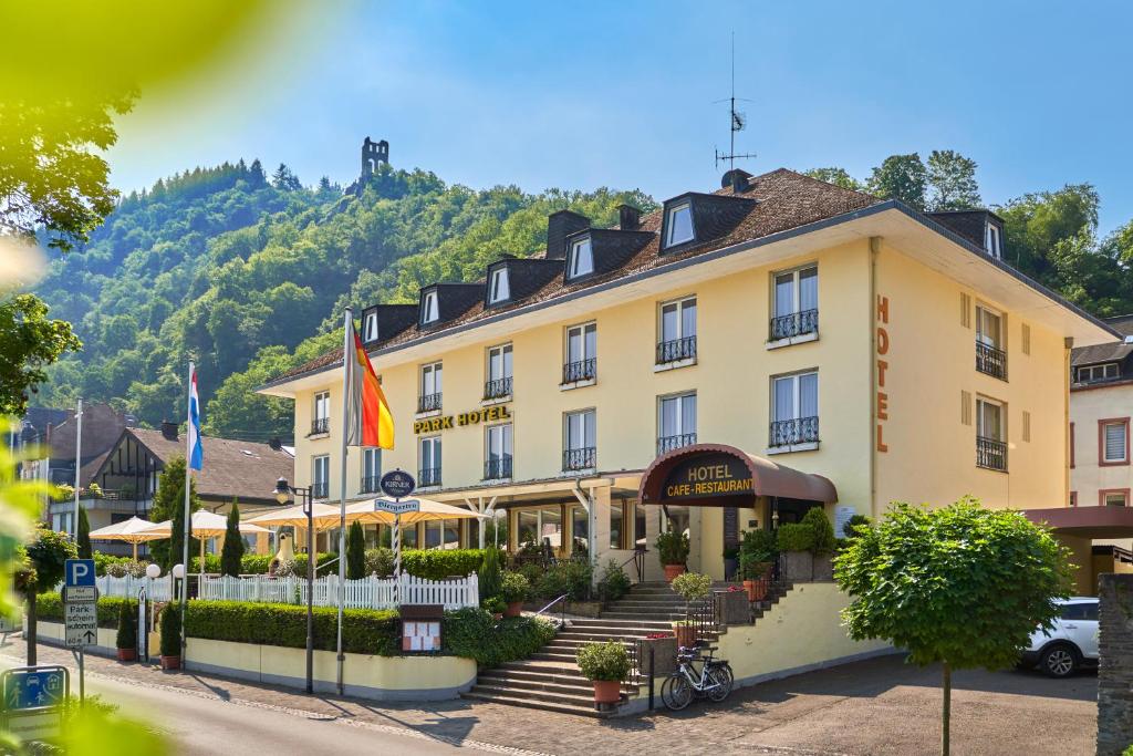 a hotel in a town with a mountain in the background at Park-Hotel Traben-Trarbach in Traben-Trarbach